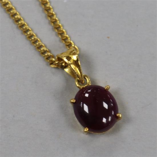A yellow metal and cabochon ruby set pendant on a 22ct gold chain.